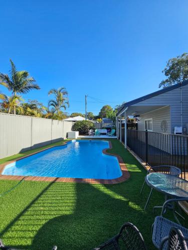 a swimming pool in the yard of a house at Cygnets in Lake Munmorah