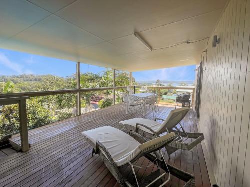 a porch with chairs and tables on a balcony at Coastal Upper-Level Home with Shared Pool Access in Batehaven