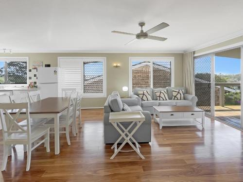 a living room with a couch and a table at Coastal Upper-Level Home with Shared Pool Access in Batehaven