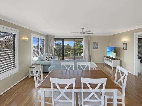 a dining room and living room with a table and chairs at Coastal Upper-Level Home with Shared Pool Access in Batehaven