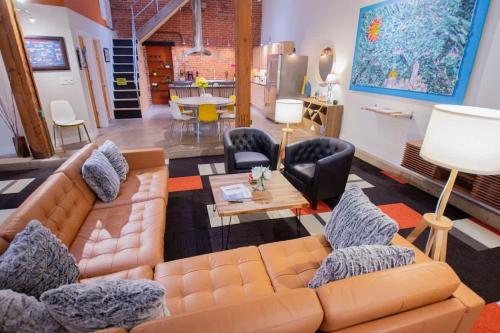 a living room with a couch and chairs and a table at Trendy Modern Loft in Rino Art District in Denver