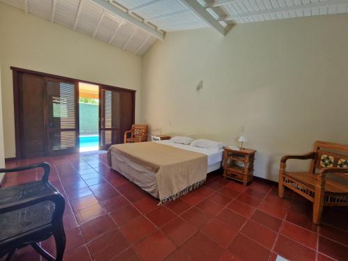 een slaapkamer met een bed, een tafel en een stoel bij Casa Colonial Cabore in Paraty