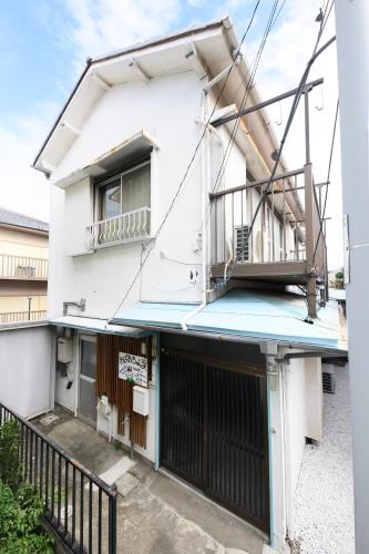 a white building with a balcony on top of it at Grandma's house - おばあちゃん家 in Numazu