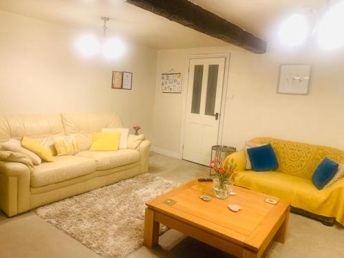 a living room with a couch and a coffee table at Tilly Cottage - overlooking Pendle Hill in Barrowford
