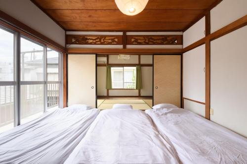 a large bed in a room with a large window at Grandma's house - おばあちゃん家 in Numazu