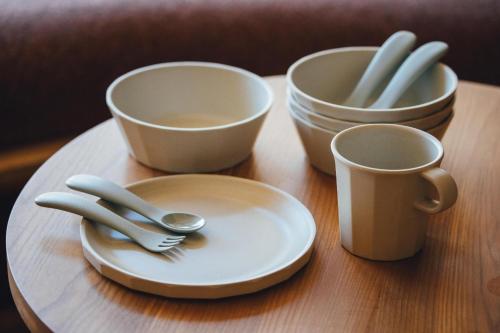 a table with three cups and a plate with a fork and spoon at SANU 2nd Home 那須2nd in Nasu