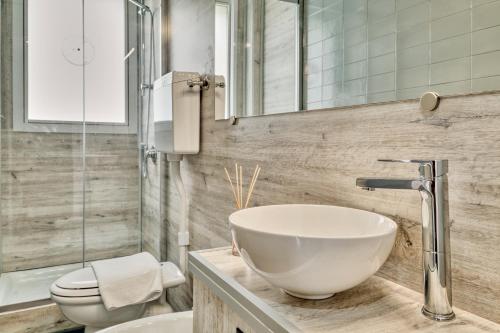a bathroom with a bowl sink and a toilet at Hotel Astoria in Bordighera