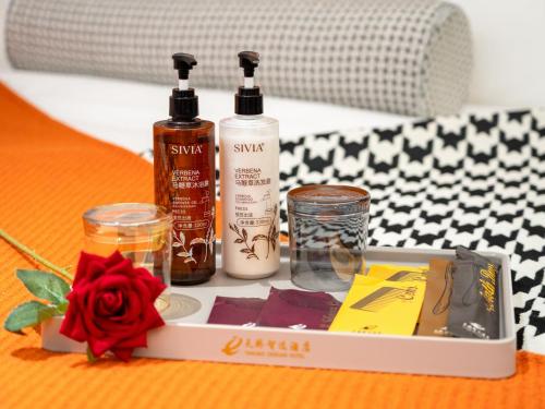 a box with three bottles and a rose on a table at Jiuquan Smart Hotel in Jiuquan