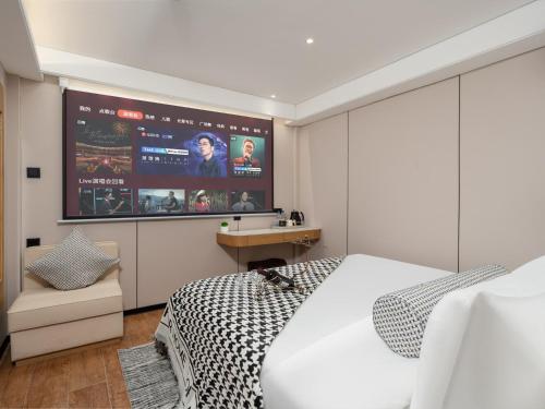 a bedroom with a bed and a large screen at Jiuquan Smart Hotel in Jiuquan