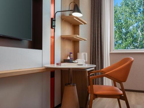a room with a table and a chair and a window at Holiday Inn Express Shangdi Beijing by IHG l Next to The Old Summer Palace & Qinghe Railway Station & Subway l Taxi 15 Minutes to Summer Palace & Peking University & Tsinghua University l 20 Minutes to Badaling Great Wall by Railway in Beijing