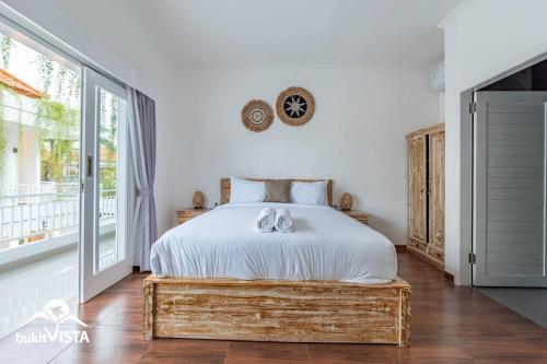 a bedroom with a bed and a large window at Mo Cactus by Bukit Vista in Tumbak Bayuh