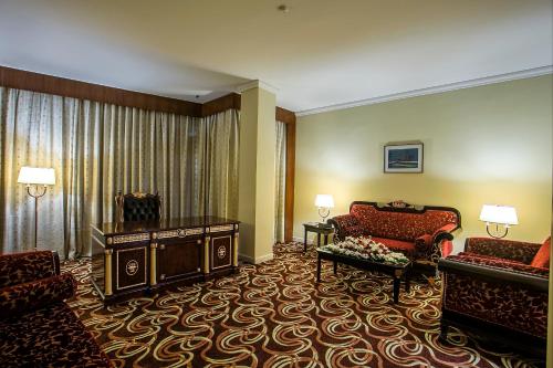 a hotel room with a couch and a chair and a living room at Rose View Hotel in Sylhet