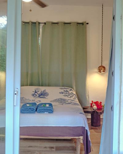 a bedroom with a bed with two blue towels on it at Casa Mariposa Puertolindo in Garrote