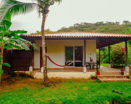 a house with a porch and a palm tree at Casa Mariposa Puertolindo in Garrote