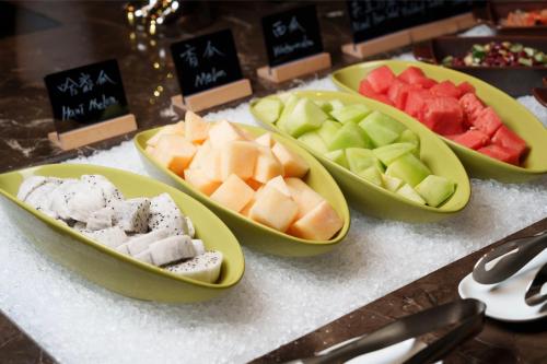 four bowls filled with different types of fruit on a counter at Novotel Nanjing Airport in Nanjing