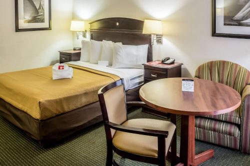 a hotel room with a bed and a table and chairs at Econo Lodge in Palm Coast