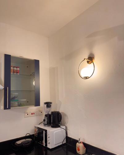 a kitchen with a blender and a light on the wall at Bahari Studio Beach Front Apartment. in Diani Beach
