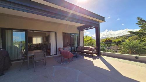 a house with a patio with a table and chairs at Beachfront Chic Penthouse in Rivière Noire