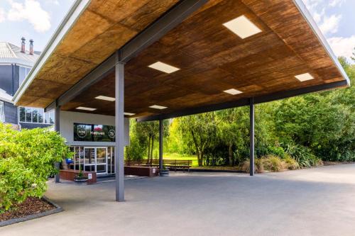 a pavilion with a wooden roof in front of a building at Methven Resort in Methven