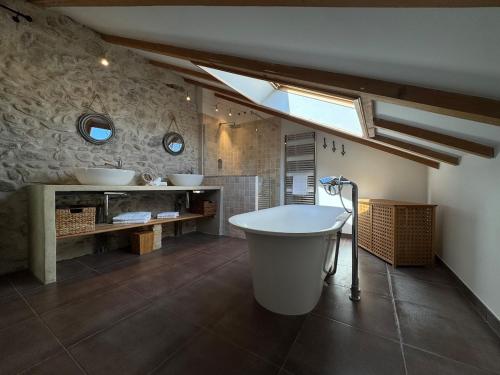 La grande salle de bains est pourvue d'une baignoire et de deux lavabos. dans l'établissement Mas Constantin - piscine, jeux pour enfants et vue sur les montagnes, à Montboucher-sur-Jabron