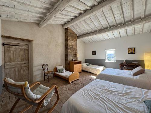 - une chambre avec deux lits et une chaise dans l'établissement Mas Constantin - piscine, jeux pour enfants et vue sur les montagnes, à Montboucher-sur-Jabron