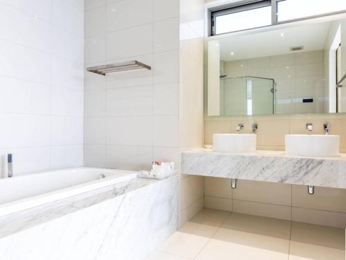 a bathroom with two sinks and a tub and a mirror at The View Phuket F9 in Kata Beach