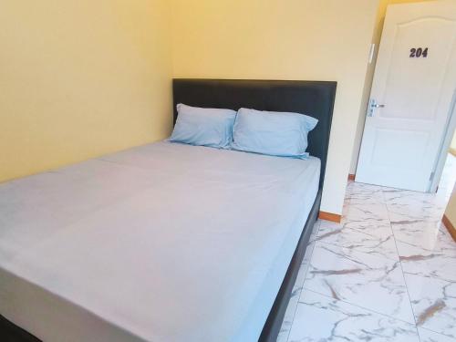 a bed with blue pillows in a room at Pomah Guesthouse in Jatingaleh