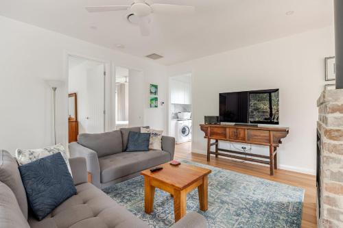 a living room with a couch and a piano at The Getaway - Galston in Galston