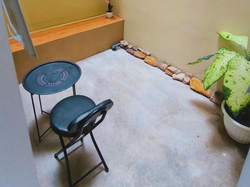 a room with a table and a chair and a plant at Pomah Guesthouse in Jatingaleh