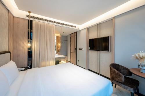 a bedroom with a large white bed and a desk at iRest Signature Ba Dinh Lakeside in Hanoi