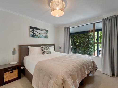 a bedroom with a bed and a large window at 6 Beds 2 Bathrooms Private Holiday Home in Akaroa