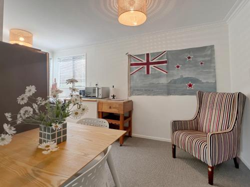 a living room with a table and a chair and a flag at 6 Beds 2 Bathrooms Private Holiday Home in Akaroa