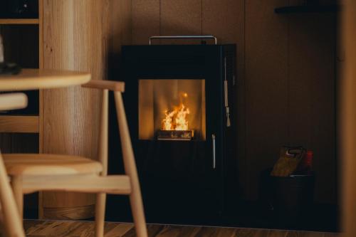 a fireplace with a fire in it in a room at SANU 2nd Home 八ヶ岳 3rd in Nagasawa