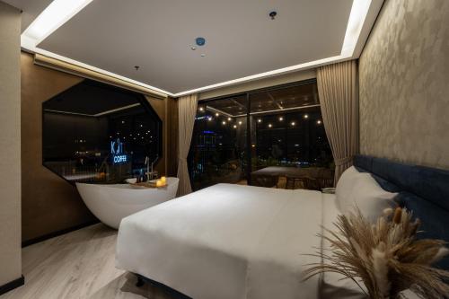 a bedroom with a bed and a tub and a window at iRest Signature Ba Dinh Lakeside in Hanoi