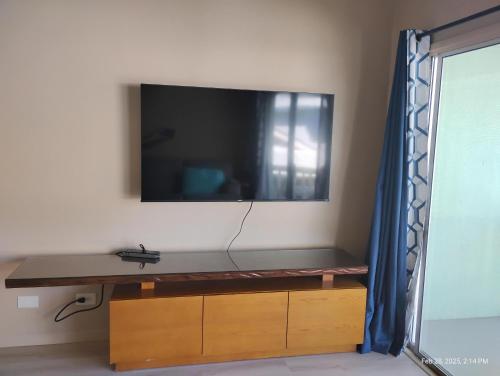 Una televisión o centro de entretenimiento en Yonegan Plumeria Hilo Hotel