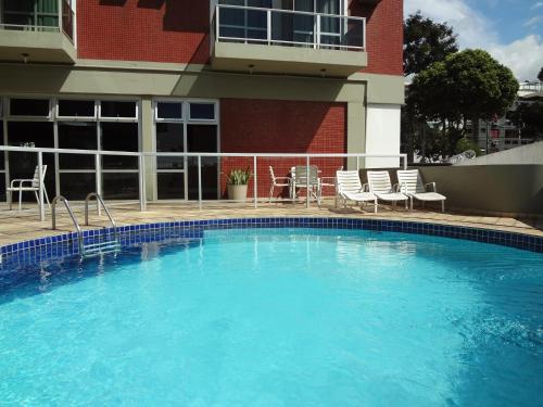 a large blue swimming pool in front of a building at Hotel Sol da Praia in Vitória