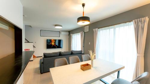 a living room with a couch and a table at Homey Inn Kujo Kawaramachi in Kyoto