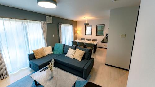 a living room with a couch and a table at Homey Inn Kujo Kawaramachi in Kyoto