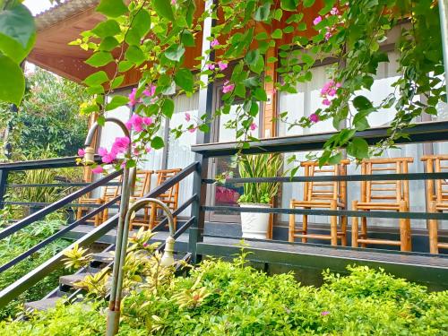 a balcony of a house with chairs and flowers at Tam Coc Sunshine Homestay in Ninh Binh