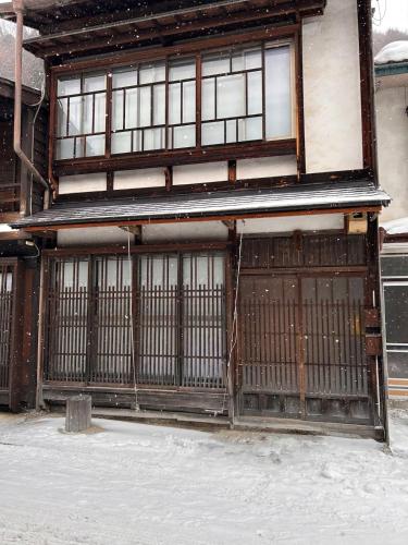 an old gate in front of a building with snow at 奈良井駅徒歩10分中山道奈良井宿古民家一棟貸し御宿美里屋 in Shiojiri