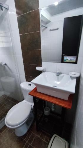 a bathroom with a white toilet and a sink at Cabañas El Itali in Fusagasuga