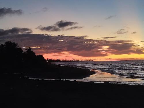 a sunset on the beach with the ocean at Habitación 6 personas in Moñitos