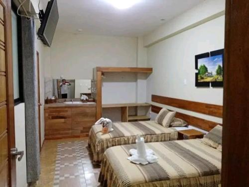 a hotel room with two beds and a sink at Casa Nativa Iquitos in Iquitos