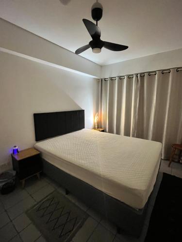 a bedroom with a bed with a ceiling fan at Apartamento Matteo in Ubatuba
