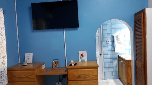 a room with a desk with a tv and a mirror at Finch Apartment in Gwa Kay