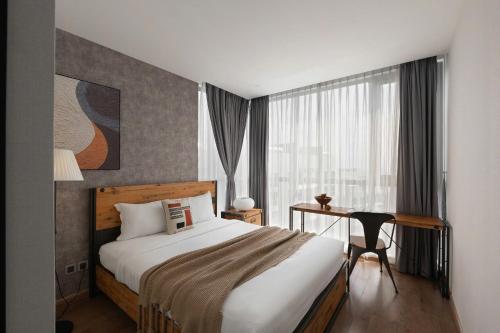 Un dormitorio con una cama y un escritorio y una ventana. en Landmark 81 Vinhomes Apartment Service, en Ho Chi Minh
