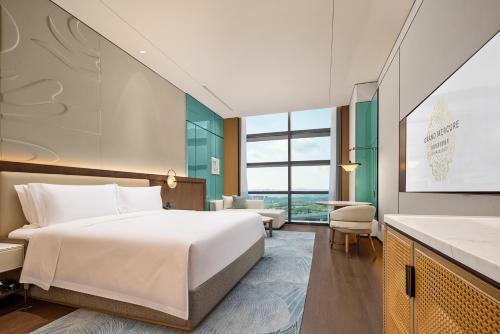 a hotel room with a bed and a large window at Grand Mercure Chengdu East in Chengdu