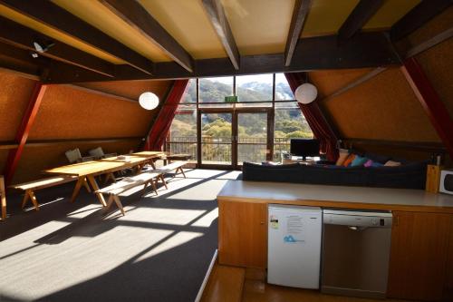 une grande pièce avec une table et des chaises et une grande fenêtre dans l'établissement Moonbah Ski Lodge, à Thredbo