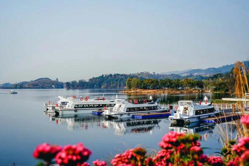 three boats are docked on a lake with flowers at Grand Mercure Chengdu East in Chengdu
