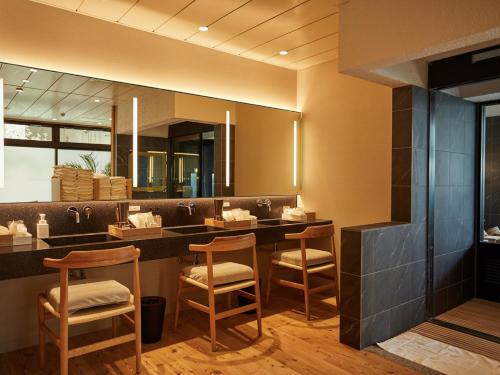 a salon with a counter with chairs and a mirror at ANDO HOTEL NARA Wakakusayama -DLIGHT LIFE & HOTELS- in Nara
